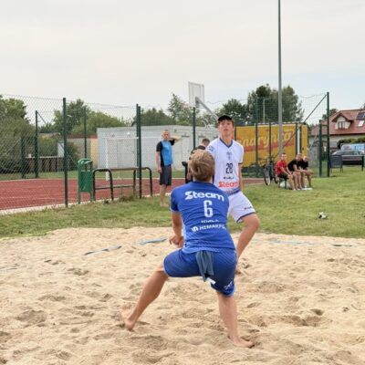 mężczyźni odbijają piłkę na piasku w siatkówkę