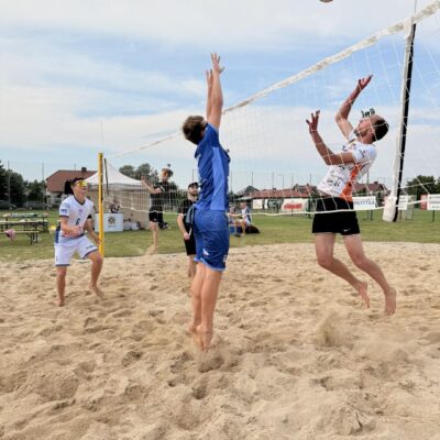 mężczyźni odbijają piłkę na piasku w siatkówkę