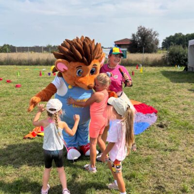 maskotka jeżyk gminy Lubin z dziećmi przytulają się