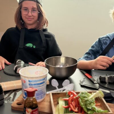 dziewczynka kroi sushi na desce