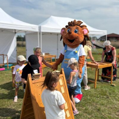 maskotka jeżyk gminy Lubin z dziećmi robią wężyka