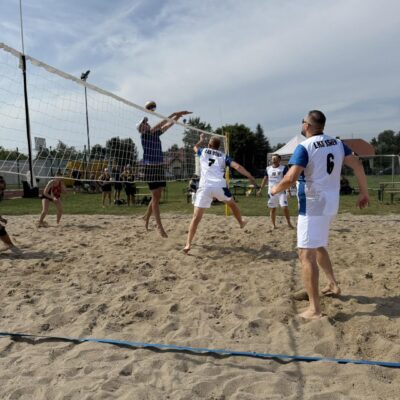 mężczyźni odbijają piłkę na piasku w siatkówkę