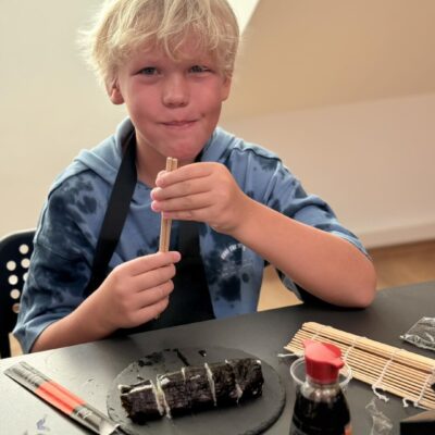 chłopiec je sushi pałeczkami