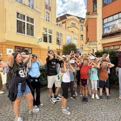 dzieci pozują do zdjęcia w rynku na placu