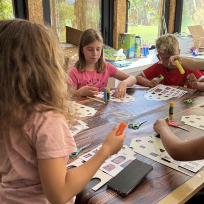 dzieci podczas warsztatów robią domki z papieru