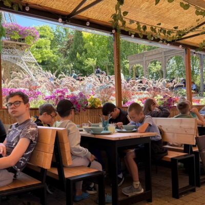 dzieci podczas posiłku siedzą przy stołach w restauracji