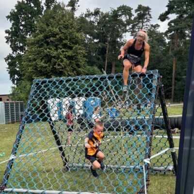 mama i chłopczyk przechodzą przez przeszkodę z siatki
