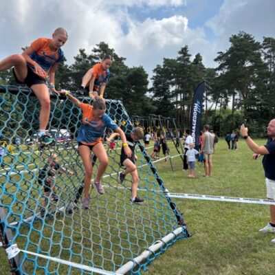 dziewczyny przechodzą przeszkodę z siatki