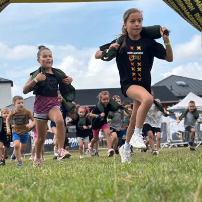 Dziewczynki z workami na barkach biegną przed siebie