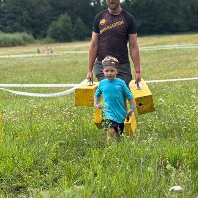 chłopczyk z tatą przenoszą przeszkodę do celu