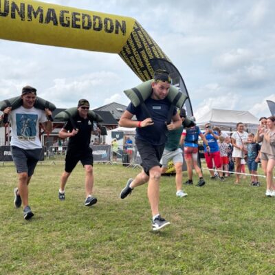 mężczyźni biegną w workami na barkach