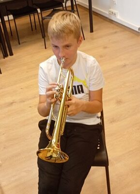 chłopiec gra na instrumencie podczas lekcji