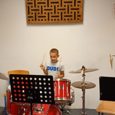 chłopiec gra na perkusji podczas lekcji