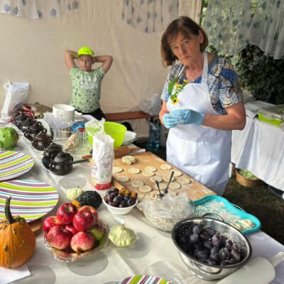 kobieta lepi pierogi przy stole