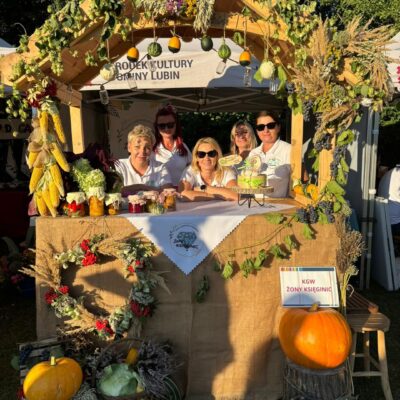 koło gospodyń pozuje do zdjęcia w domku