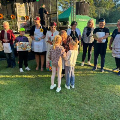 dzieci odbierają nagrody za konkurs pod sceną