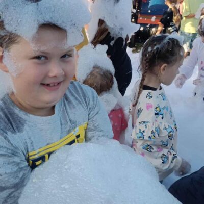 chłopiec w piana party z pianą na głowie