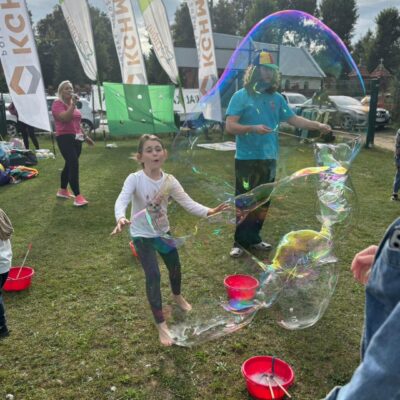 dziewczynka goni ogromną bańkę mydlaną