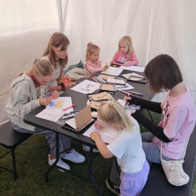 warsztaty malowania na szkle dzieci siedza przy stole i malują