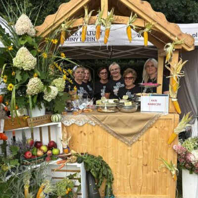 koło gospodyń pozuje do zdjęcia w domku