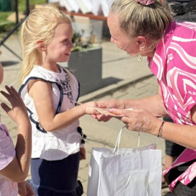 Pani sołtys wręcza dziewczynce nagrodę