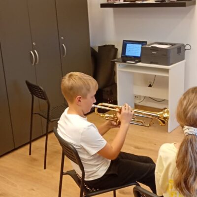 chłopiec gra na instrumencie podczas lekcji