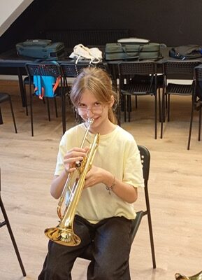 dziewczynka gra na instrumencie podczas lekcji
