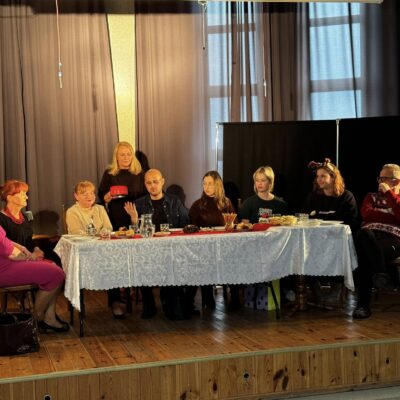 aktorzy siedzący za stołem, w czasie II aktu sztuki