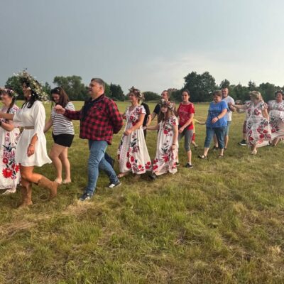 Biorący udział w imprezie i wójt, idą w rytmie poloneza nad CZARNĄ RZEKĘ